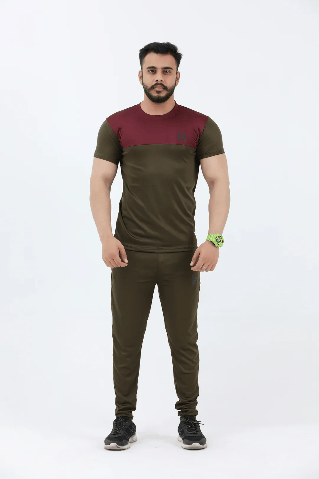 Man wearing a green and maroon athletic outfit on a white background