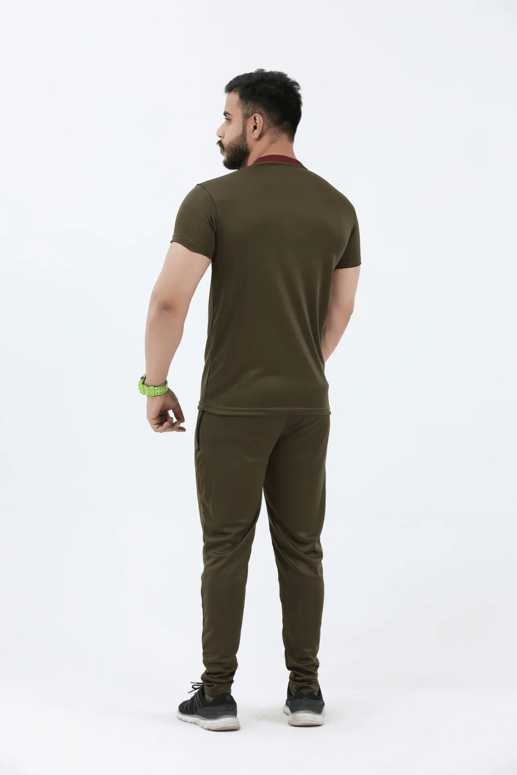Man wearing an olive green t-shirt and pants on a white background
